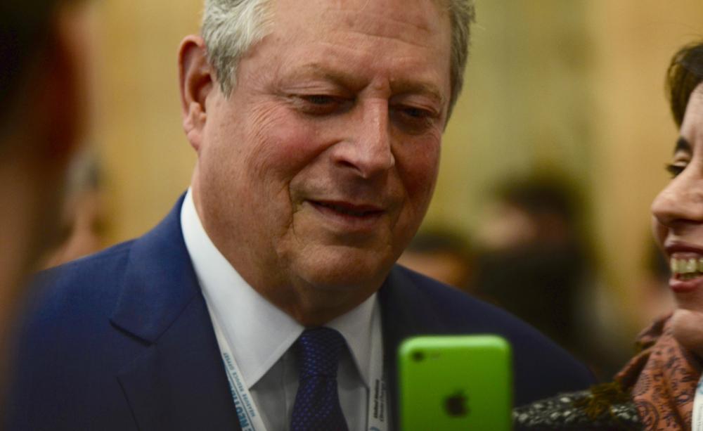 Al Gore viewing a selfie taken at the Paris negotiations in 2015.