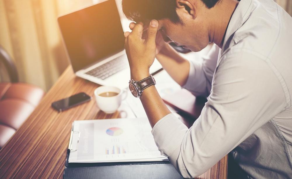 A man looking stressed at his desk