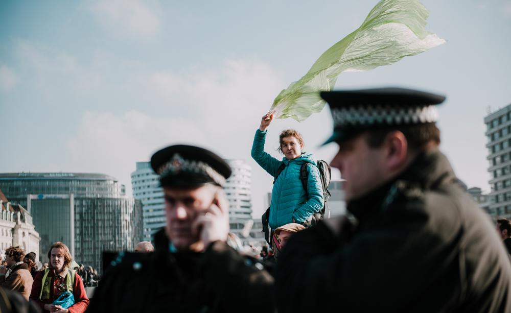 Woman flying a scarf from Westminster Bridge on XR day of action