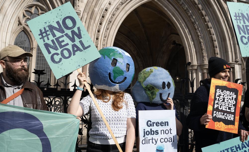 Campaigners celebrated their victory outside the High Court Campaigners with placards celebrated their victory outside the High Court