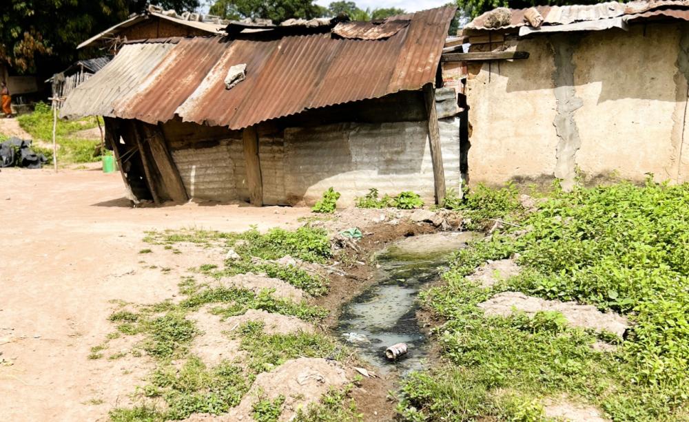 Ramshackle tin roof building with open sewer