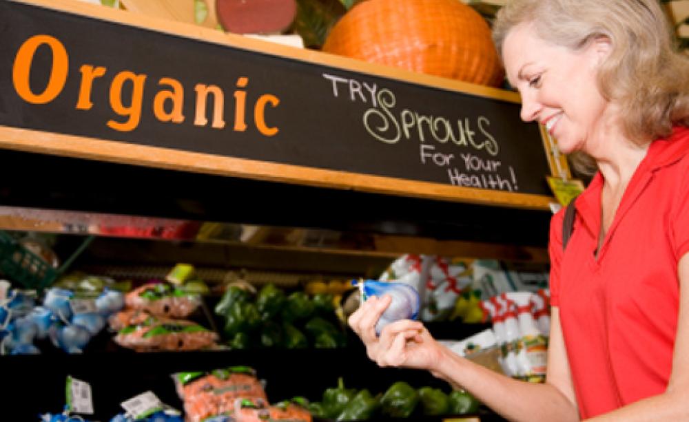 Older lady shopping for garlic in organic aisle