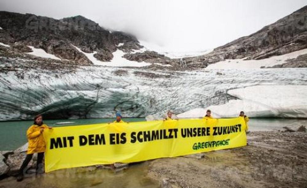 Greenpeace action for an Arctic Sanctuary in front of the melting mouth of Austria's Goldbergkees glacier. The banner reads "our future is melting with the ice".