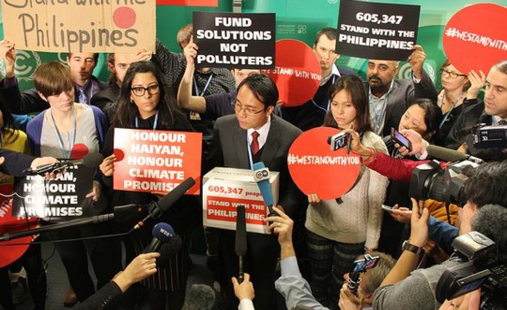 The world stood with Yeb Sano and the Philippines in 2013 - but now the Philippines are dumping him and the principled policies he represented. Photo: Handing over 600k solidarity messages to Yeb Sano at the Warsaw COP, by Push Europe (CC BT-NC 2.0).