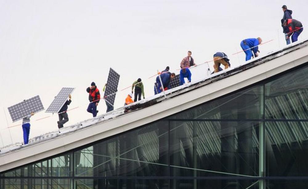 Greenpeace Energy, Germany's largest energy co-op, installing 21,132 photovoltaic modules with a peak power output of 3,800 kW on the 80,000 square roof of Stuttgart Exhibition Planet Energy. Photo: © Dirk Wilhelmy / Greenpeace Energy eG.