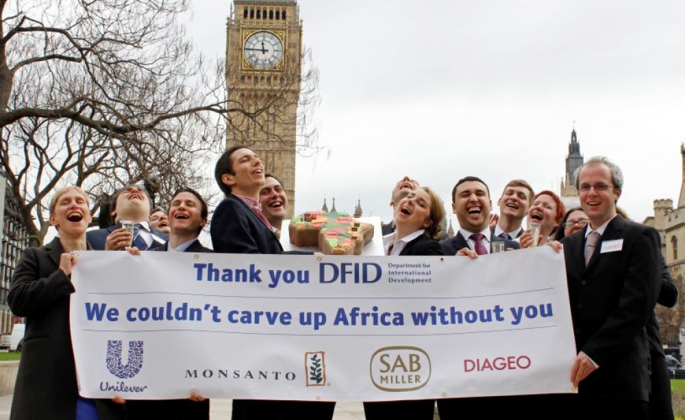 Global Justice Now supporters dressed as business people from Monsanto, Diageo, SABMiller and Unilever campaigning against the Department for International Development's involvement with the 'New Alliance'. Photo: Global Justice Now via Flickr (CC BY 2.0)