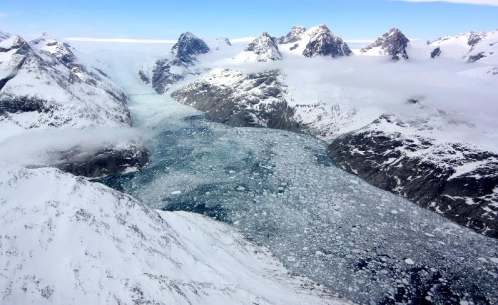 A Mélange of Ice ... a glacier pours from the Greenland ice sheet between two mountain peaks into a narrow valley on its journey to the sea. Photo: NASA's Earth Observatory via Flickr (CC BY).