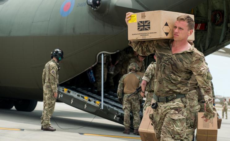 A Royal Marine Commando unloading aid supplies from a RAF C-130.
