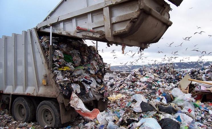 A rubbish truck dumps waste at a landfill site