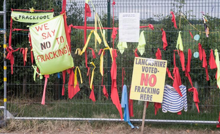 Placards and ribbons on a fence at an anti-fracking protest