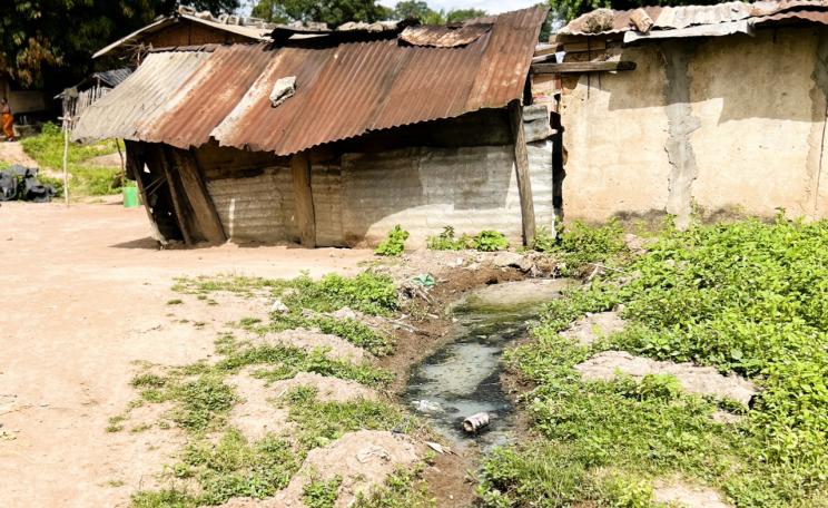  Ramshackle tin roof building with open sewer