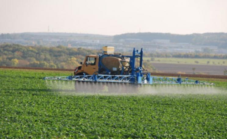 Farmer spraying crops with pesticides