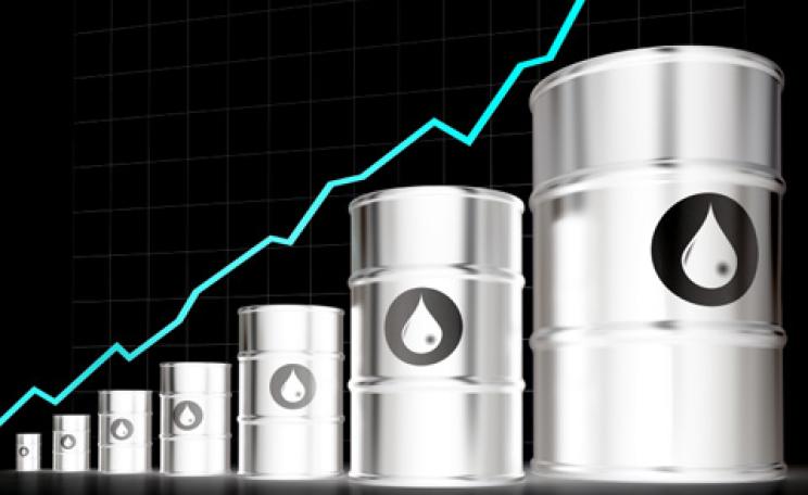 a rising price line behind oil barrels
