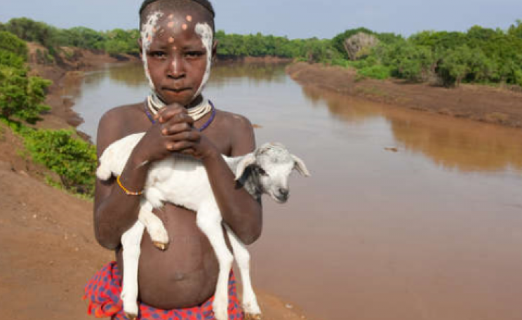 A boy from the Lower Omo stands on the riverbank. Photo: © Survival