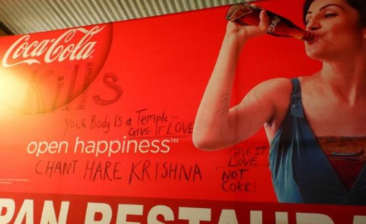 Give it love, not Coke - defaced Coca-Cola poster in Rishikesh, India. Photo: Axel Drainville via Flickr.