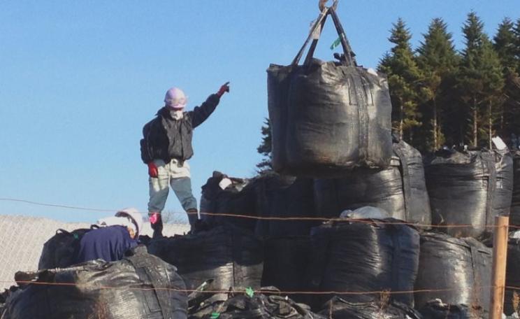 Contaminated earth storage area within the Iitate Village evacuated zone, December 2014. Photo: Eric Schultz / EELV Fukushima via Flickr (CC BY-NC-SA).