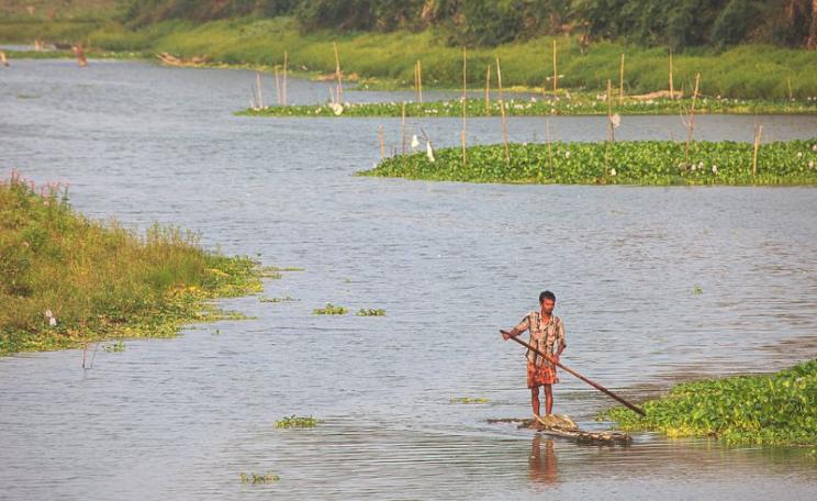 A local fisherman navigates the Diphlu River, which runs alongside India's Kaziranga national park - which operates a strict 'shoot on sight' policy for people found within the park boundaries. Photo: Frank Boyd via Flickr (CC BY-NC-SA).