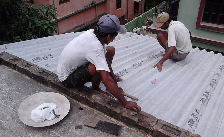 A corrugated asbestos roof is installed on a roof in India. The low cost material is still used regularly in developing countries (c) Biswarup Ganguly