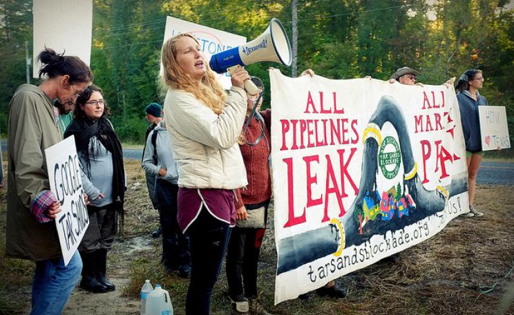 A woman shouts into a megaphone at a tar sands blockade in Canada (c) Laura Borealis