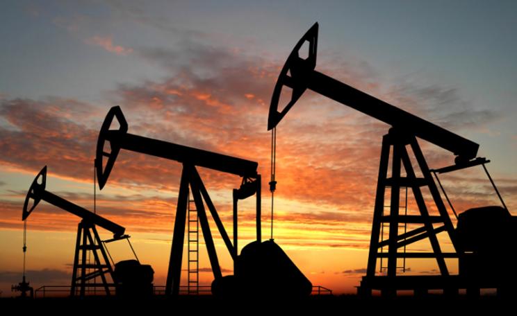 Silhouette of oil pumpjacks in a setting sun
